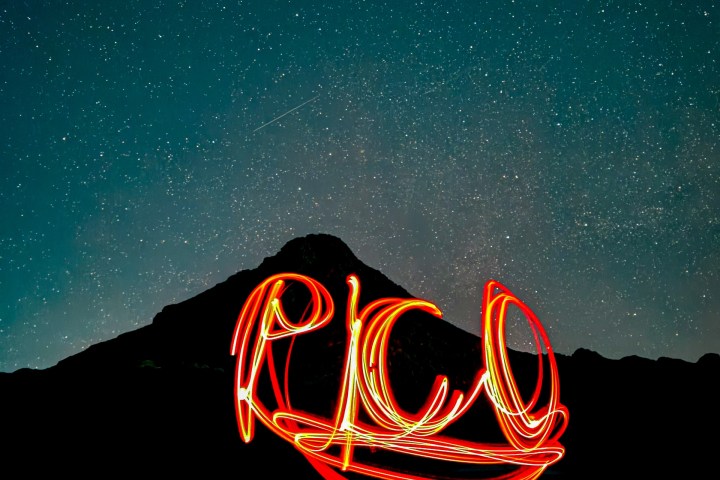 Word 'PICO' in light painting with a starry night sky and mountain silhouette.