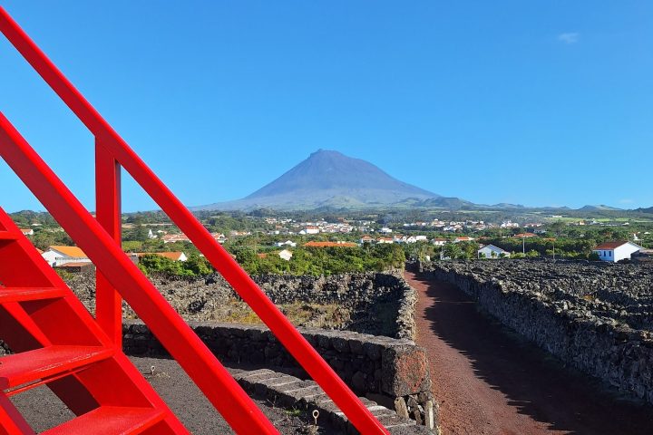 Red stairs with a mountain and clear blue sky in the background.