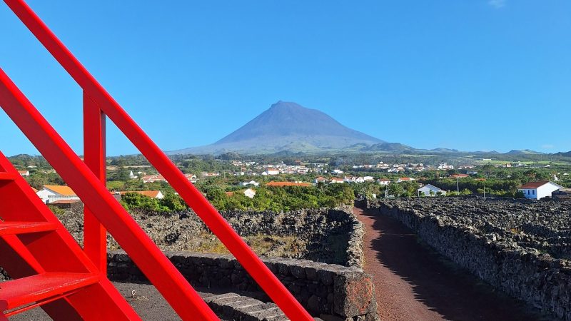 Red stairs with a mountain and clear blue sky in the background.